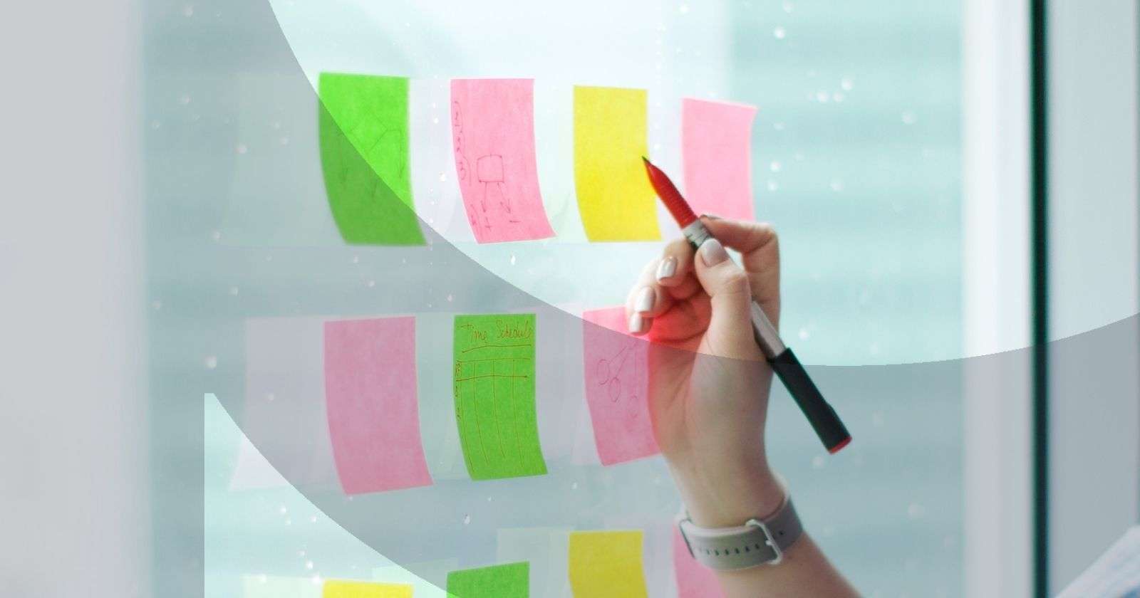 Hand writing on colorful sticky notes on a window
