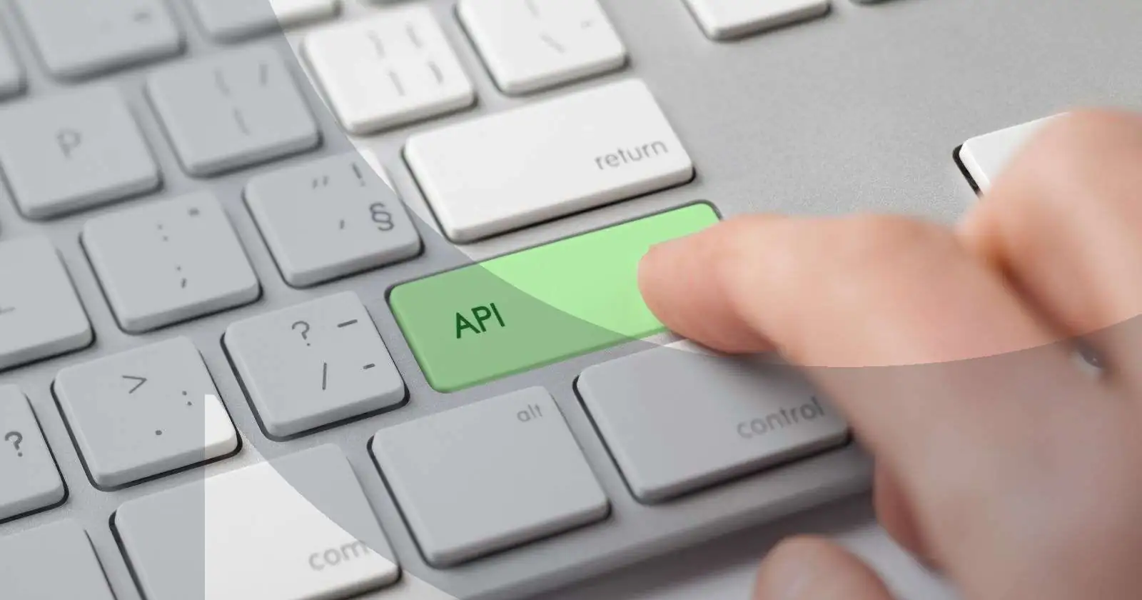 Finger pressing green API key on computer keyboard