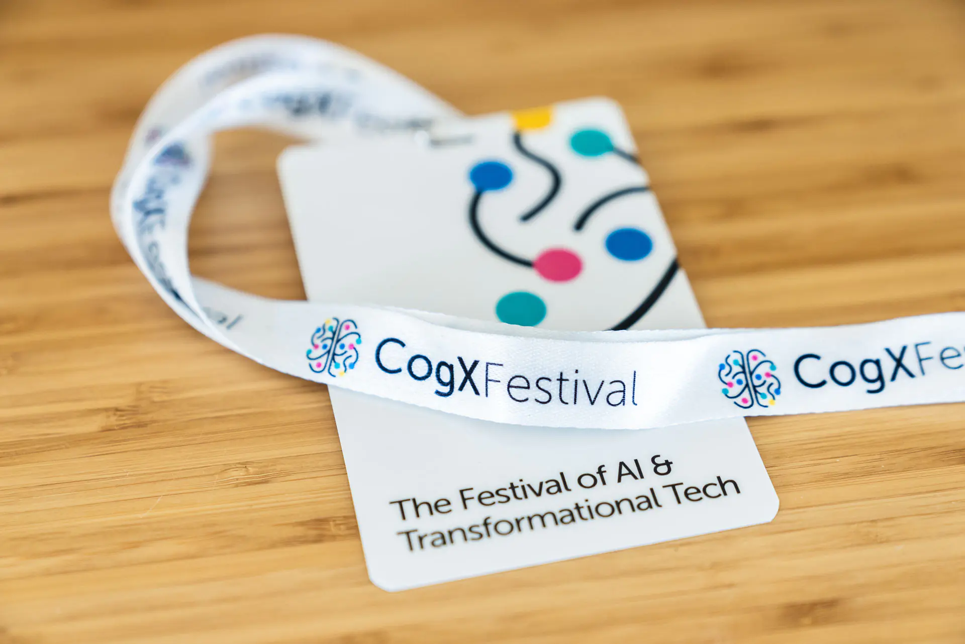 CogX Festival badge with colorful neural design on table; text: "The Festival of AI & Transformational Tech."