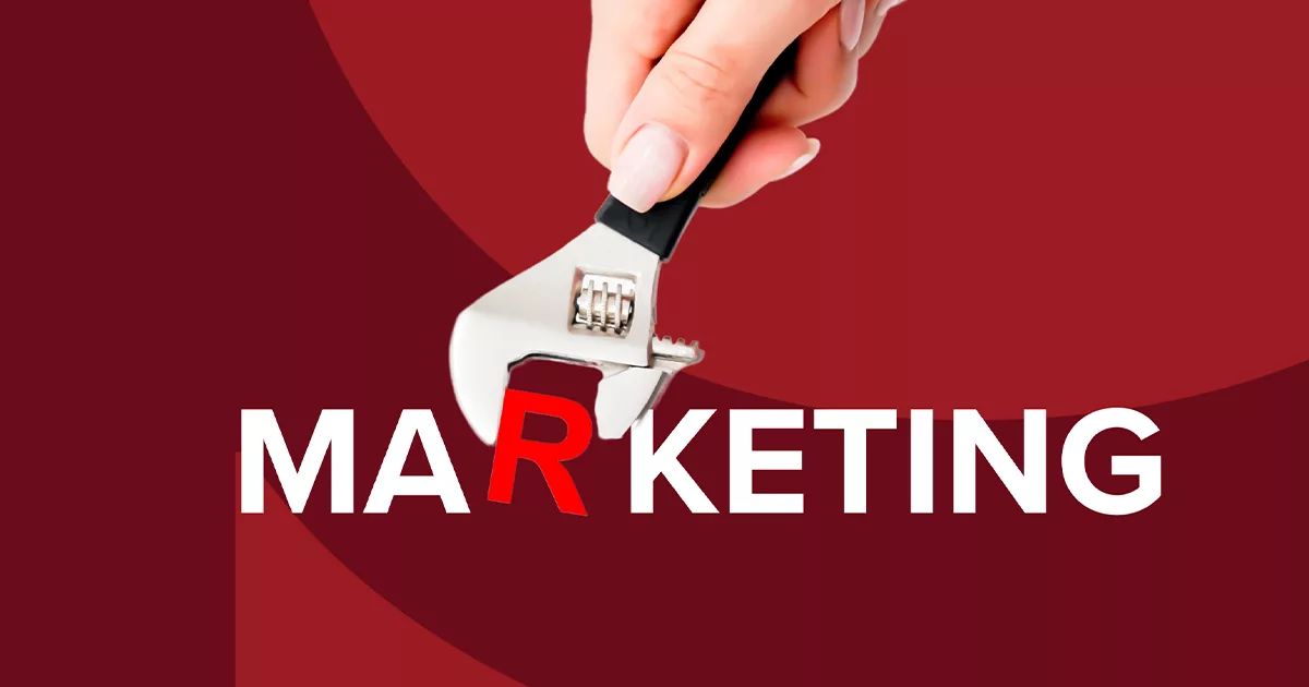 Hand using wrench to twist 'R' in 'Marketing' on red background