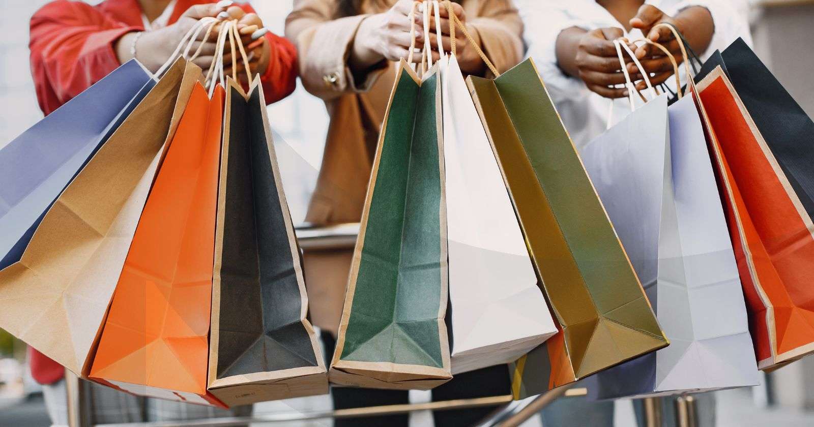Happy shoppers carry shopping bags at a shopping mall