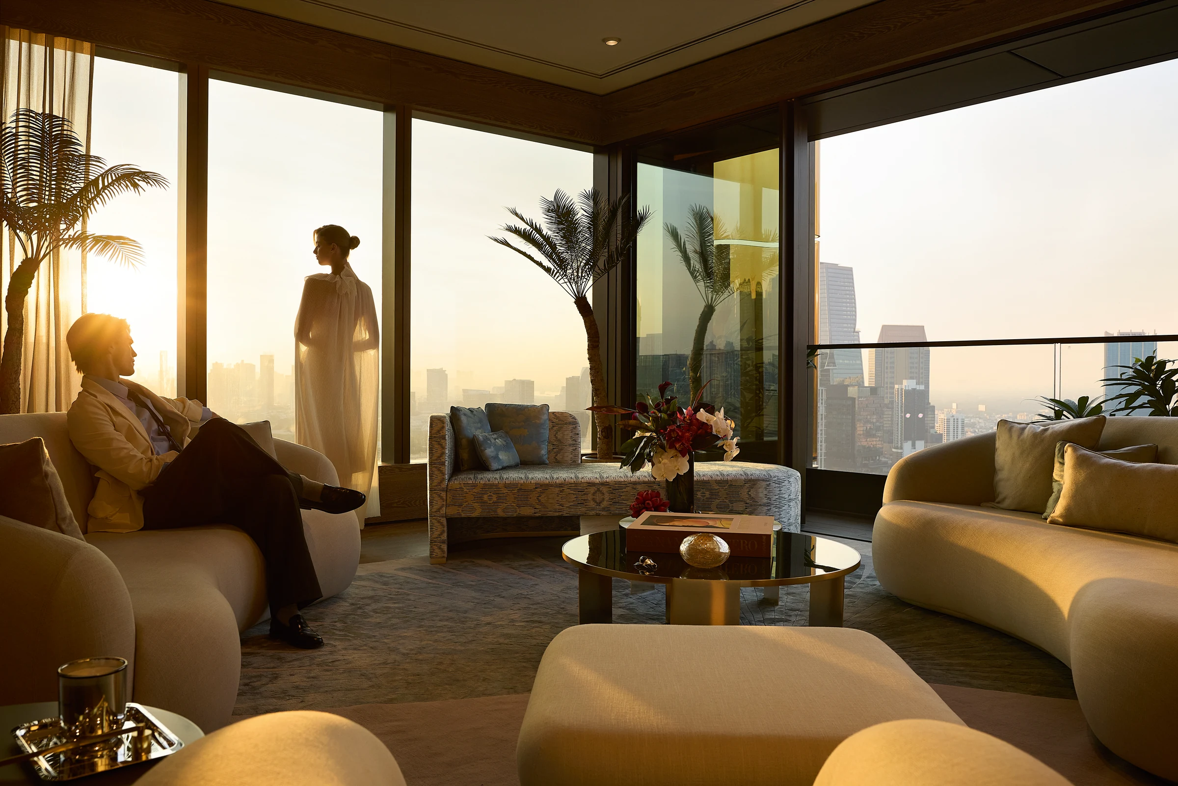A Sunrise Residence living room with floor-to-ceiling windows overlooking Bangkok.