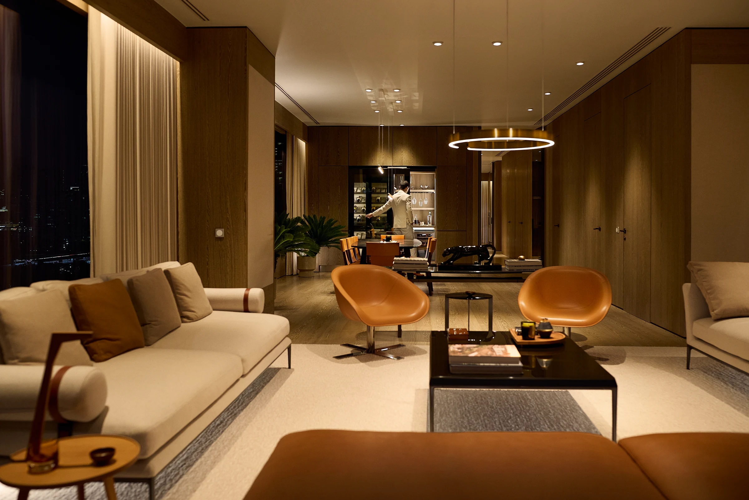 A Sunset Residence living and dining room illuminated in warm evening light.