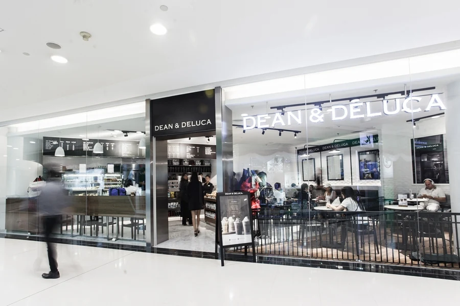 A DEAN & DELUCA cafe storefront with an open seating area.