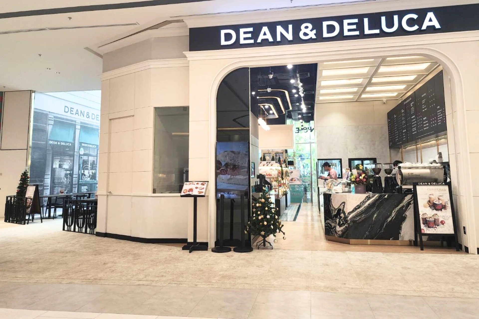 A DEAN & DELUCA storefront framed by a wide arch.