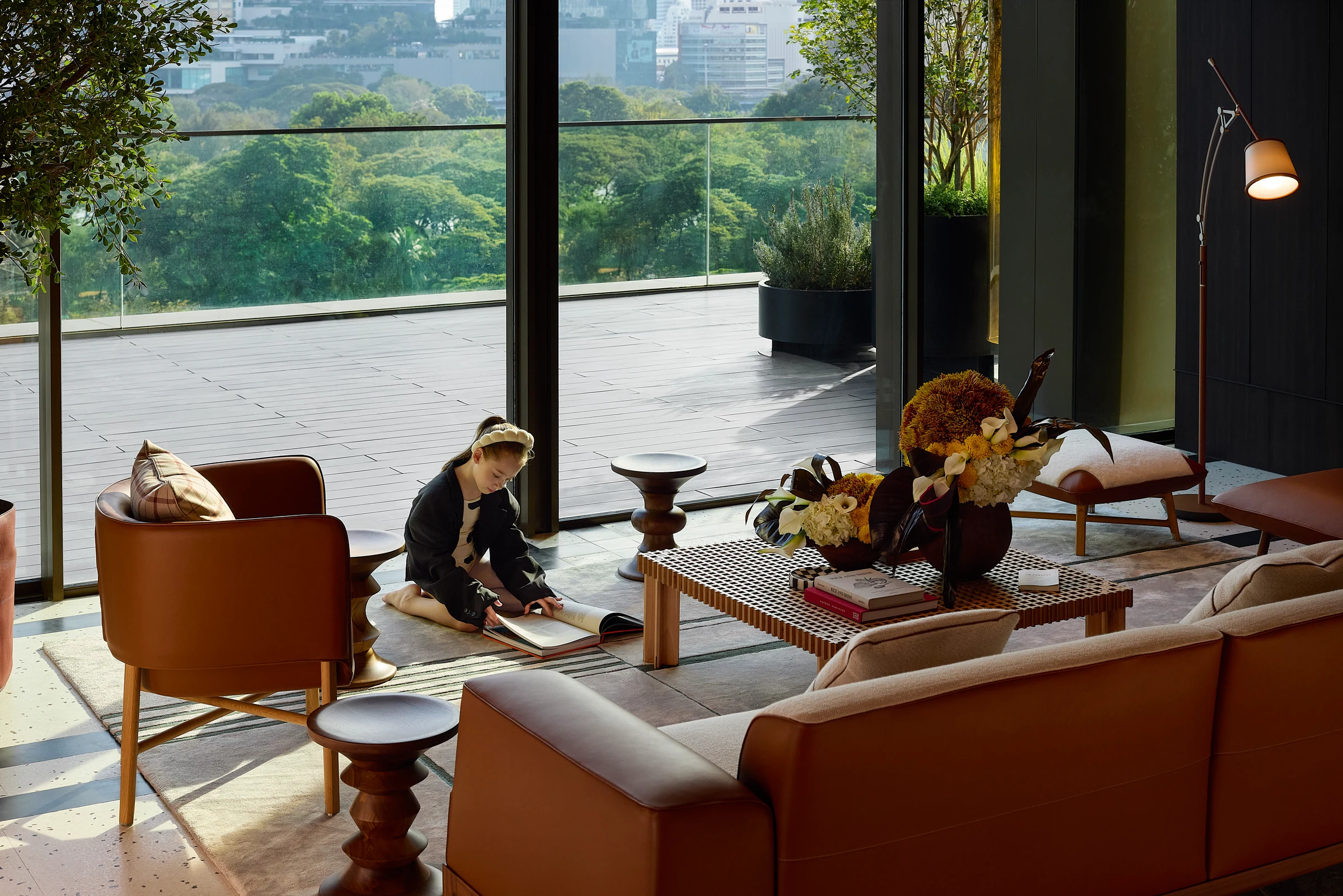 Residents spending time in a lounge overlooking a green park.