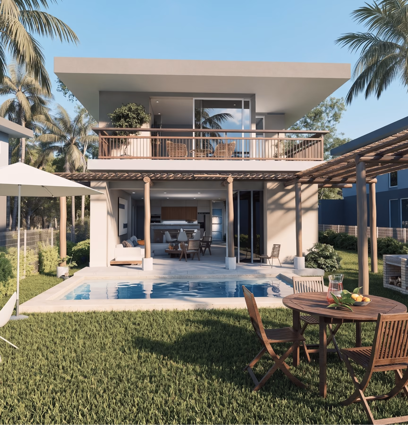 Modern two-story house with a large balcony, open living area on the ground floor, and a swimming pool in the backyard surrounded by green grass, wooden patio furniture with a pitcher and fruit, and palm trees under a clear blue sky.