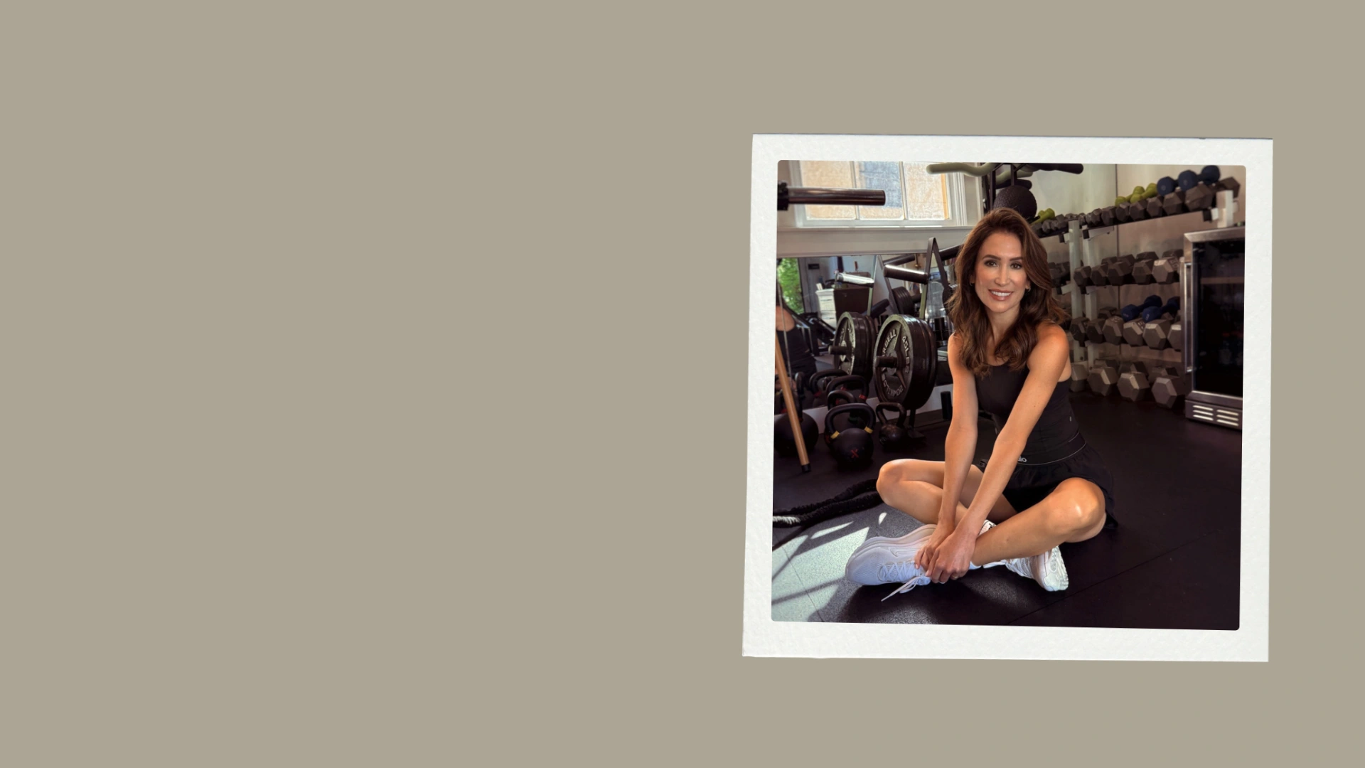 Founder Katie Gabriel seated on the gym floor in Club KMO in Jacksonville, FL, with strength training equipment in the background.
