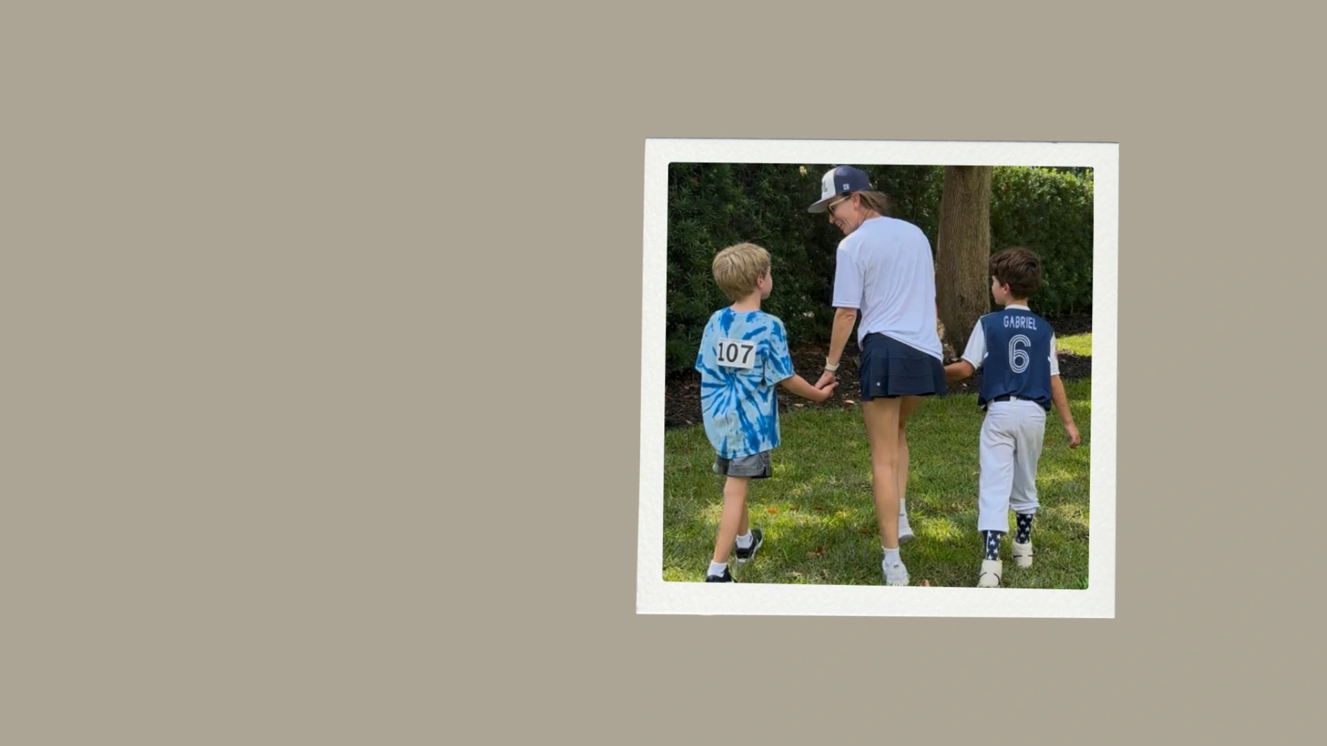 Coach walking outdoors holding hands with two children, reflecting Club KMO's family-focused fitness community in Jacksonville, FL.