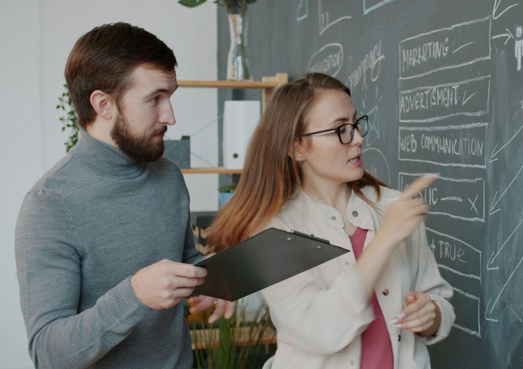 Two students at a chalkboard in the classroom