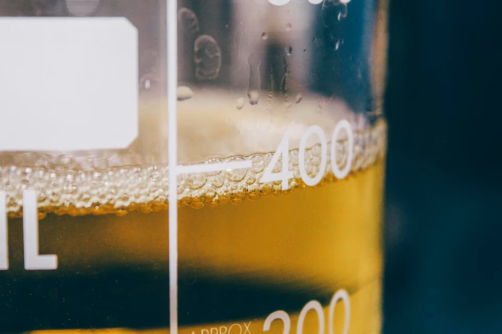 Close-up of a clear glass container filled with a yellow liquid marked near the 400ml measurement.