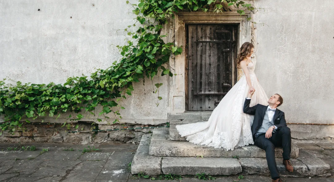 Romantic couple posing against an ancient stone wall