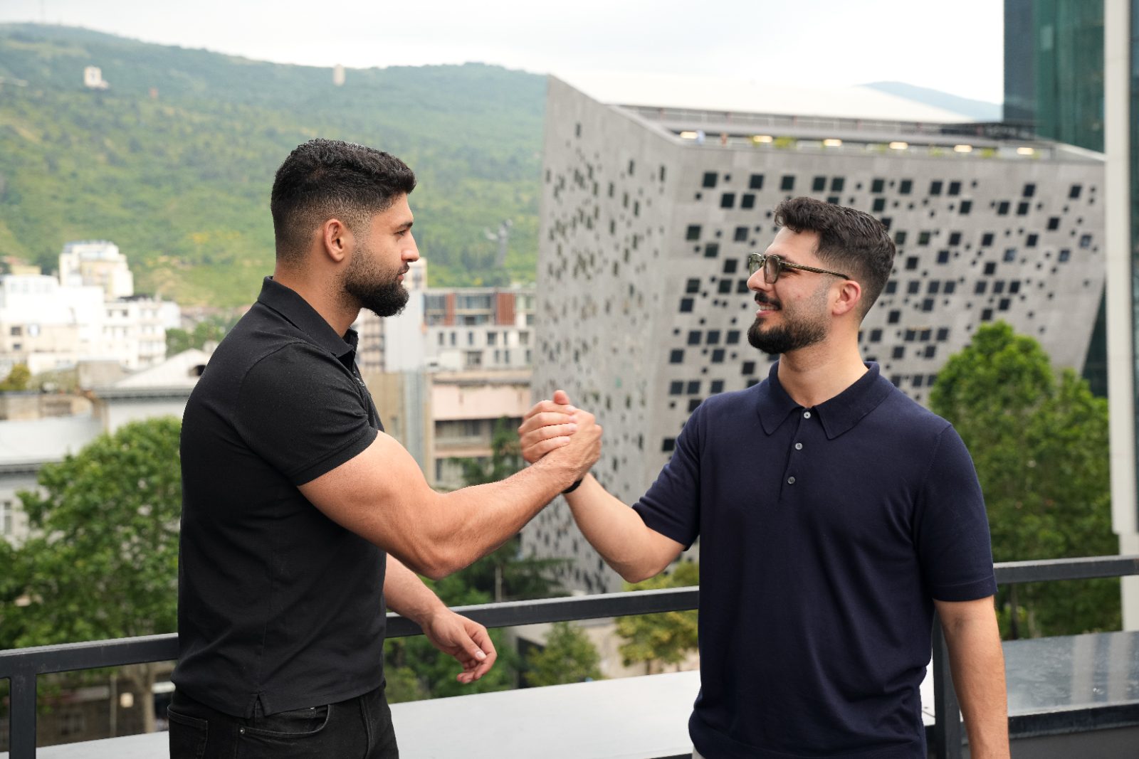 Handschlag vor moderner Architektur in Tiflis