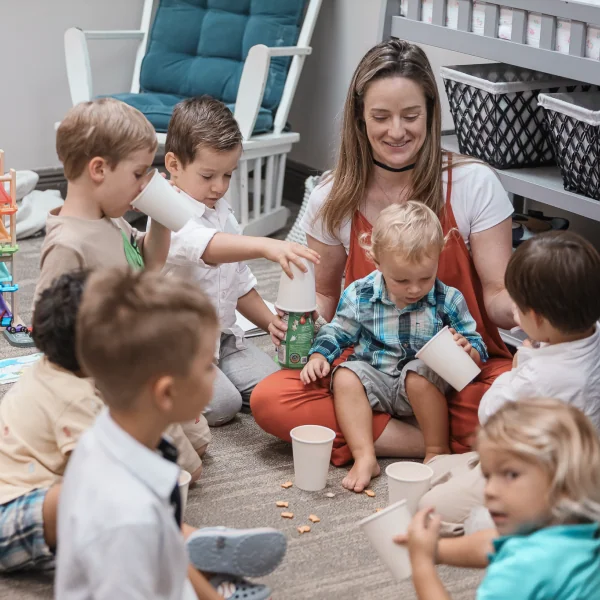 Children playing with cups indoors, representing The Sanctuary Kids Teams volunteer ministry.