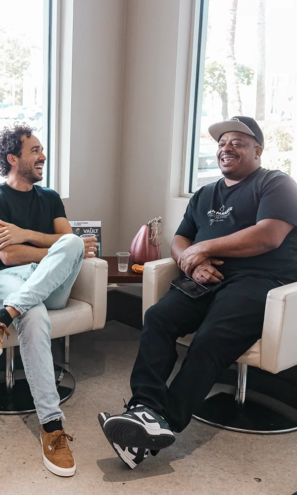 Two men laughing together in an office setting.