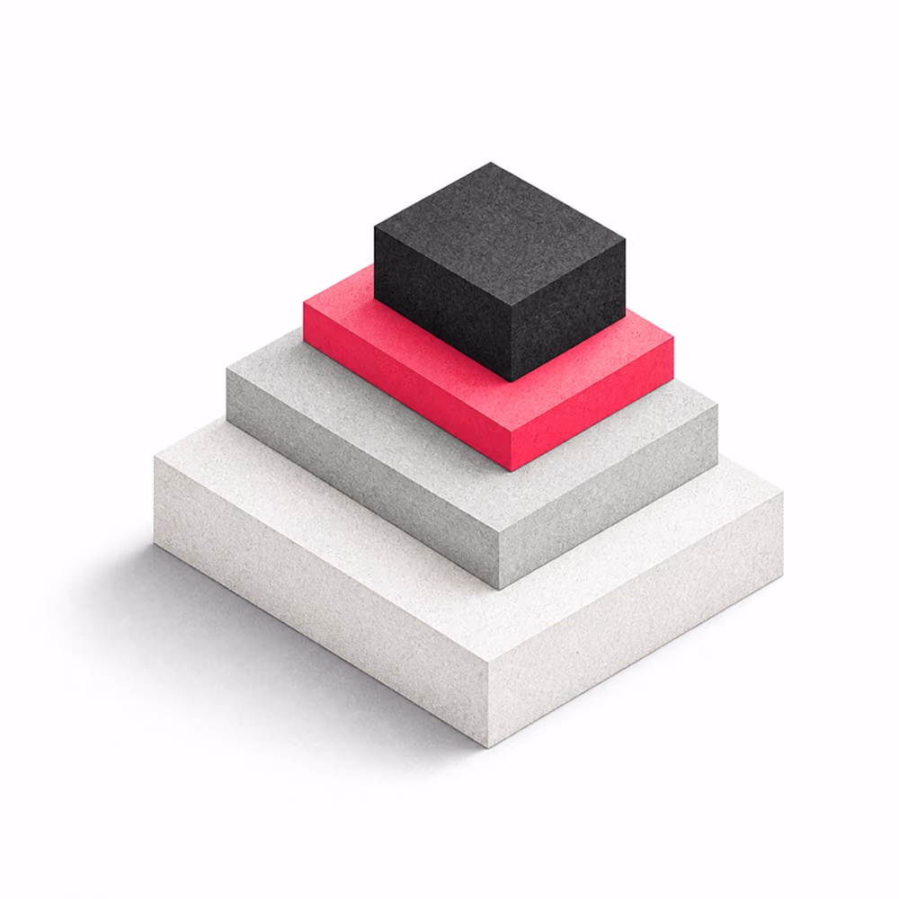Four stacked rectangular blocks forming a stepped pyramid, with the largest block white at the base, followed by a light gray block, a bright pink block, and a smaller black block on top.