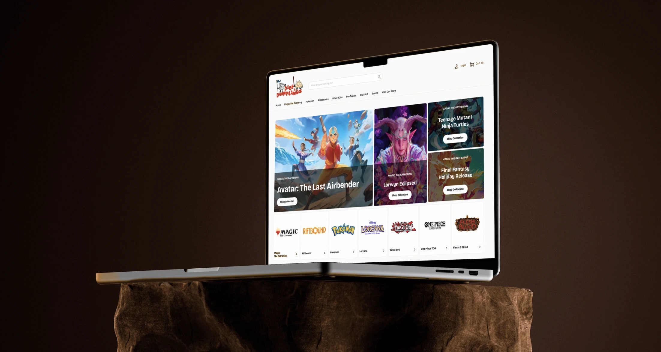 Open laptop on stone pedestal displaying a gaming and trading card website homepage.
