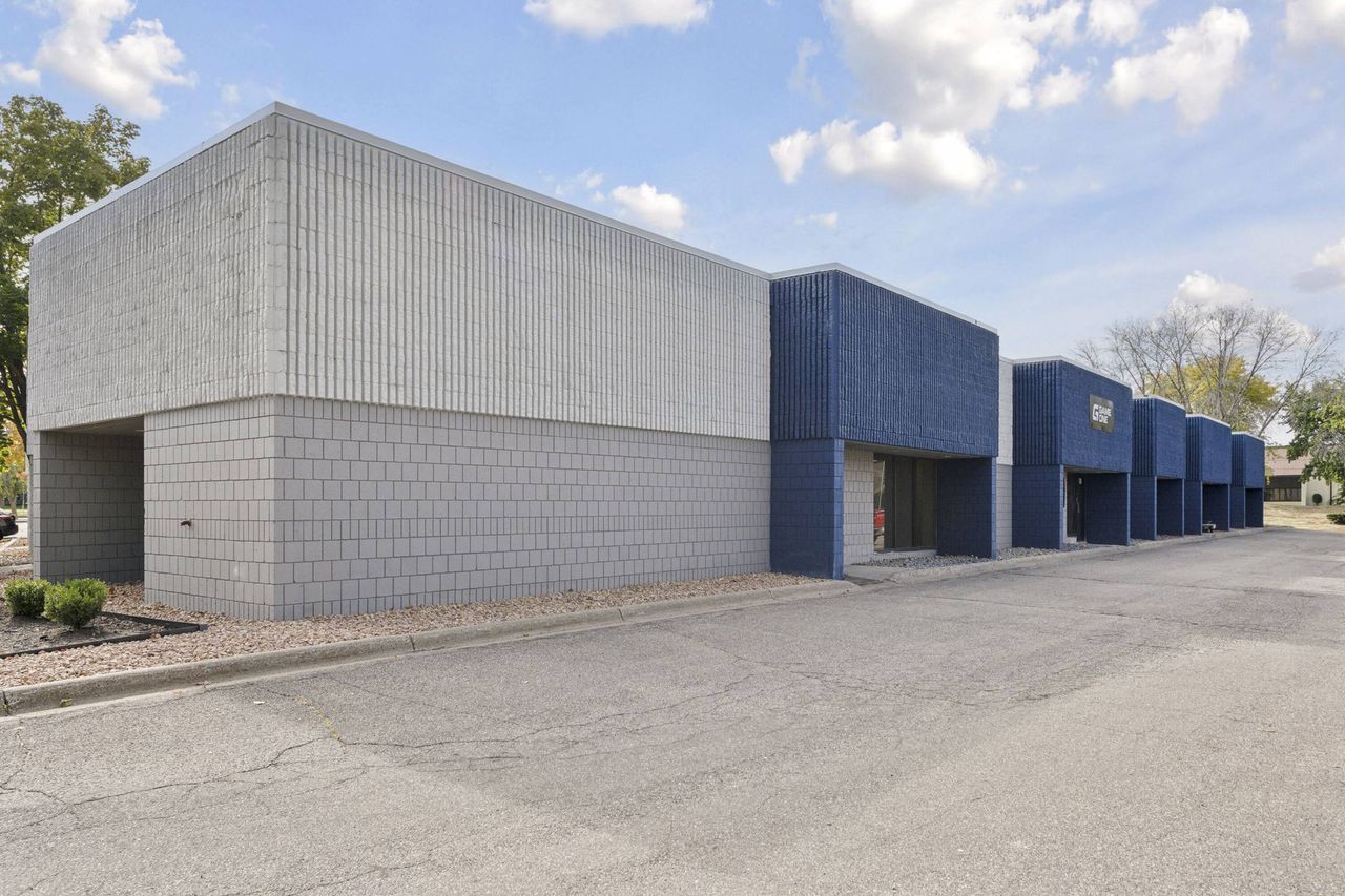Concrete block building with a receding row of blue projecting entry bays