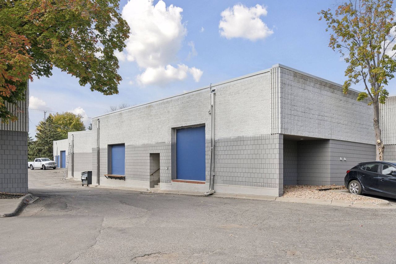 Rear elevation with two blue overhead loading doors and a pedestrian door