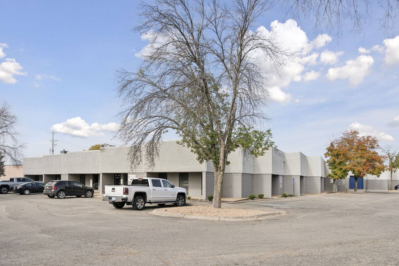 Light grey block building across the parking lot with a bare tree in the foreground