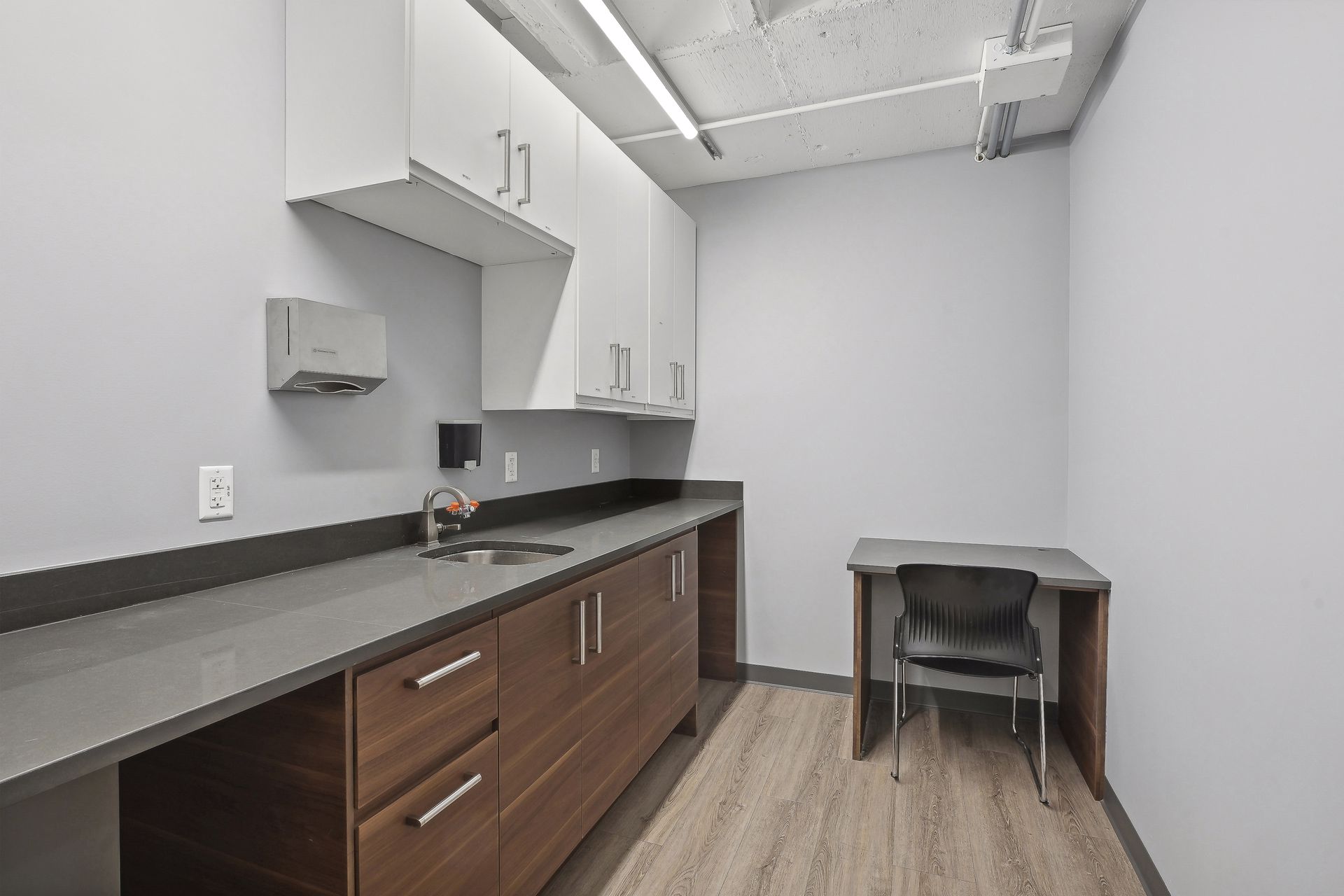 Shared kitchenette with quartz counter and walnut cabinetry