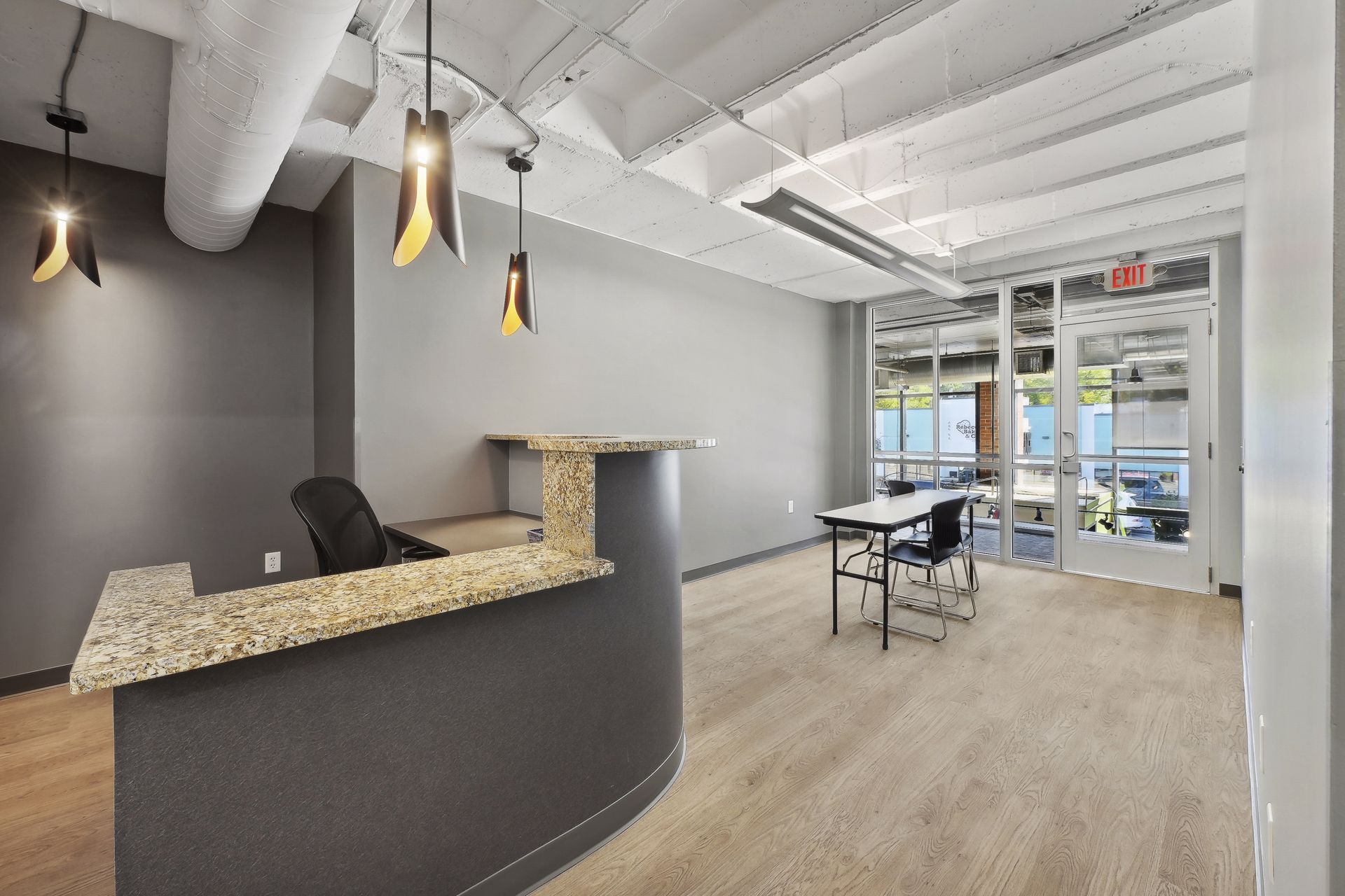 Suite reception with stone-top desk and pendant lighting