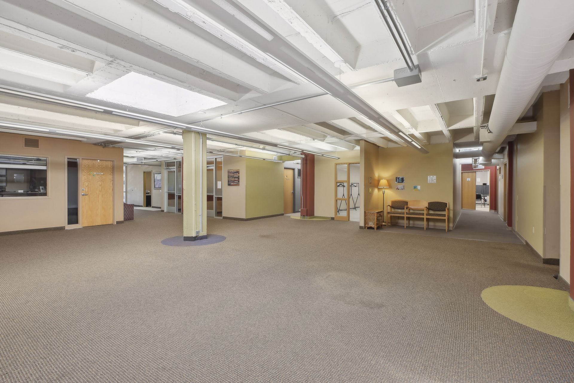 Wide open common area with tan walls and clusters of seating
