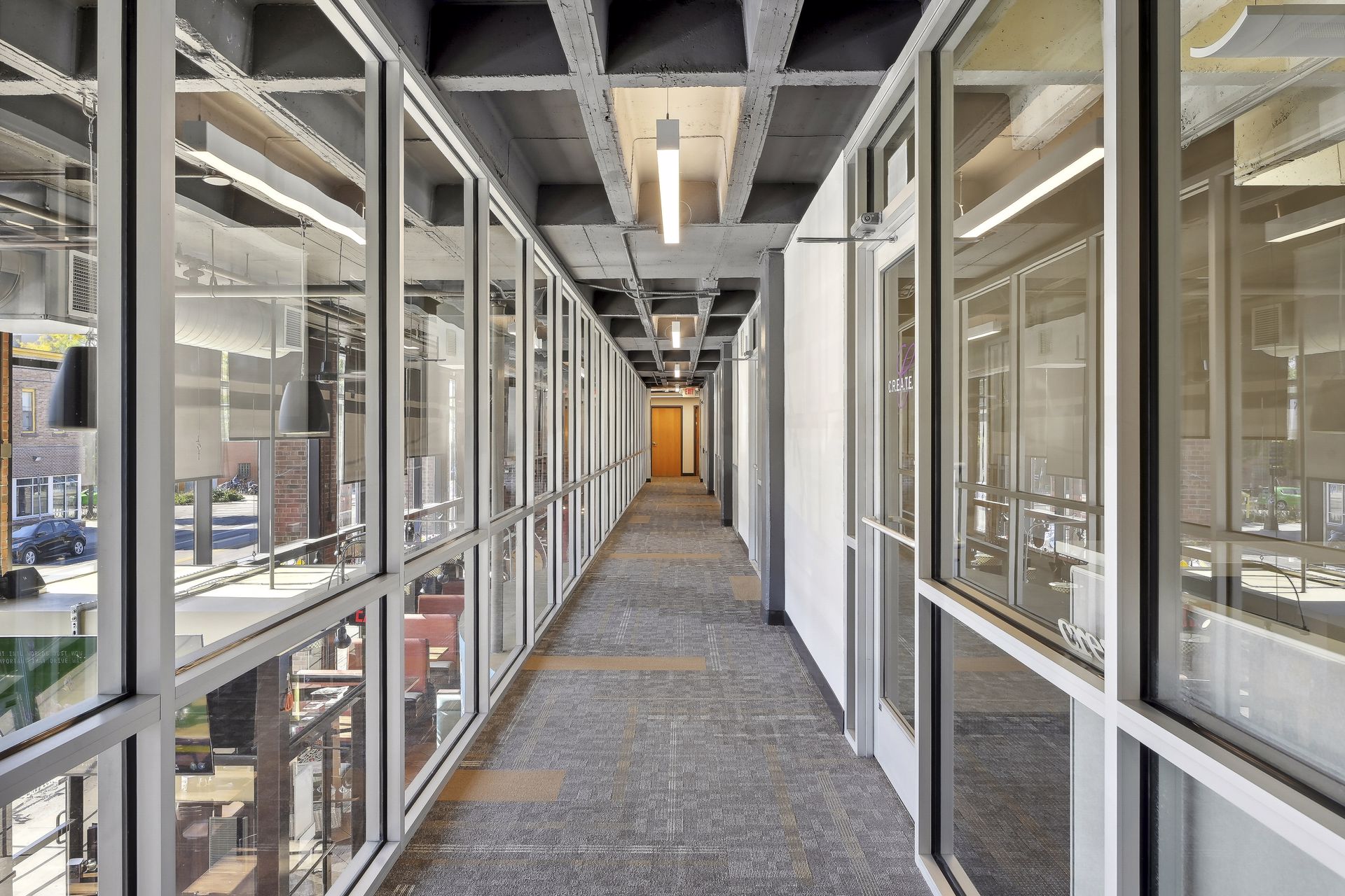 Glazed mezzanine corridor with glass on both sides overlooking the atrium