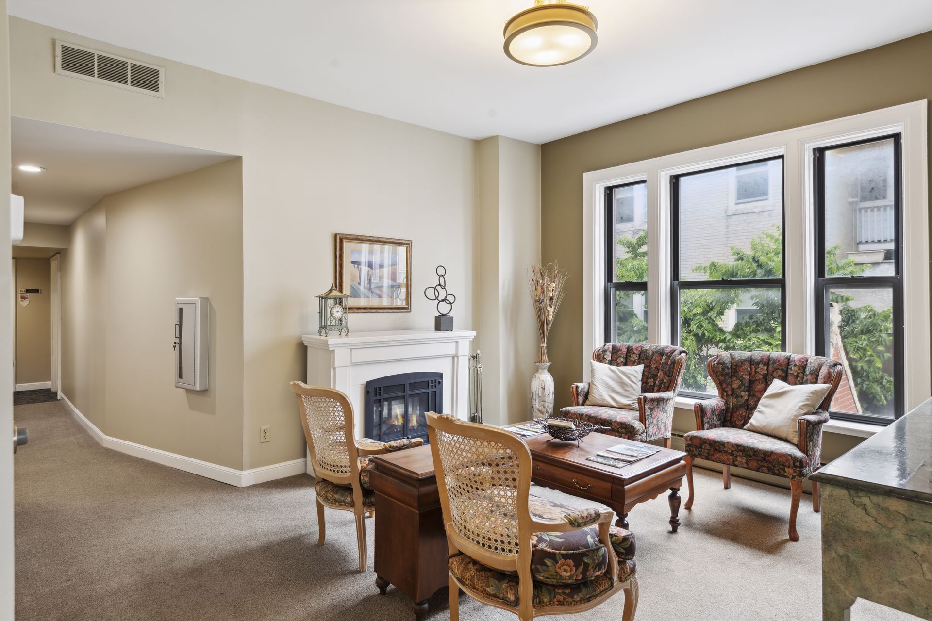 Wider view of the fireplace sitting room with the corridor visible at left