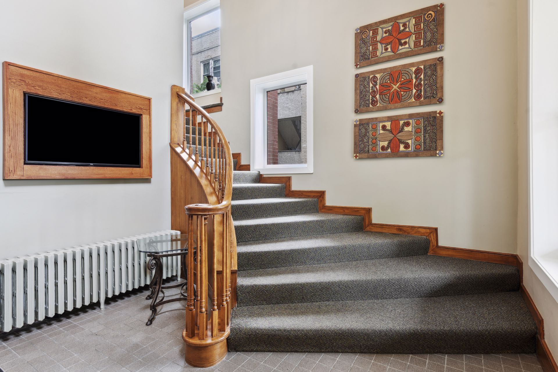 Closer view of the curved oak staircase and turned newel post in the stair hall