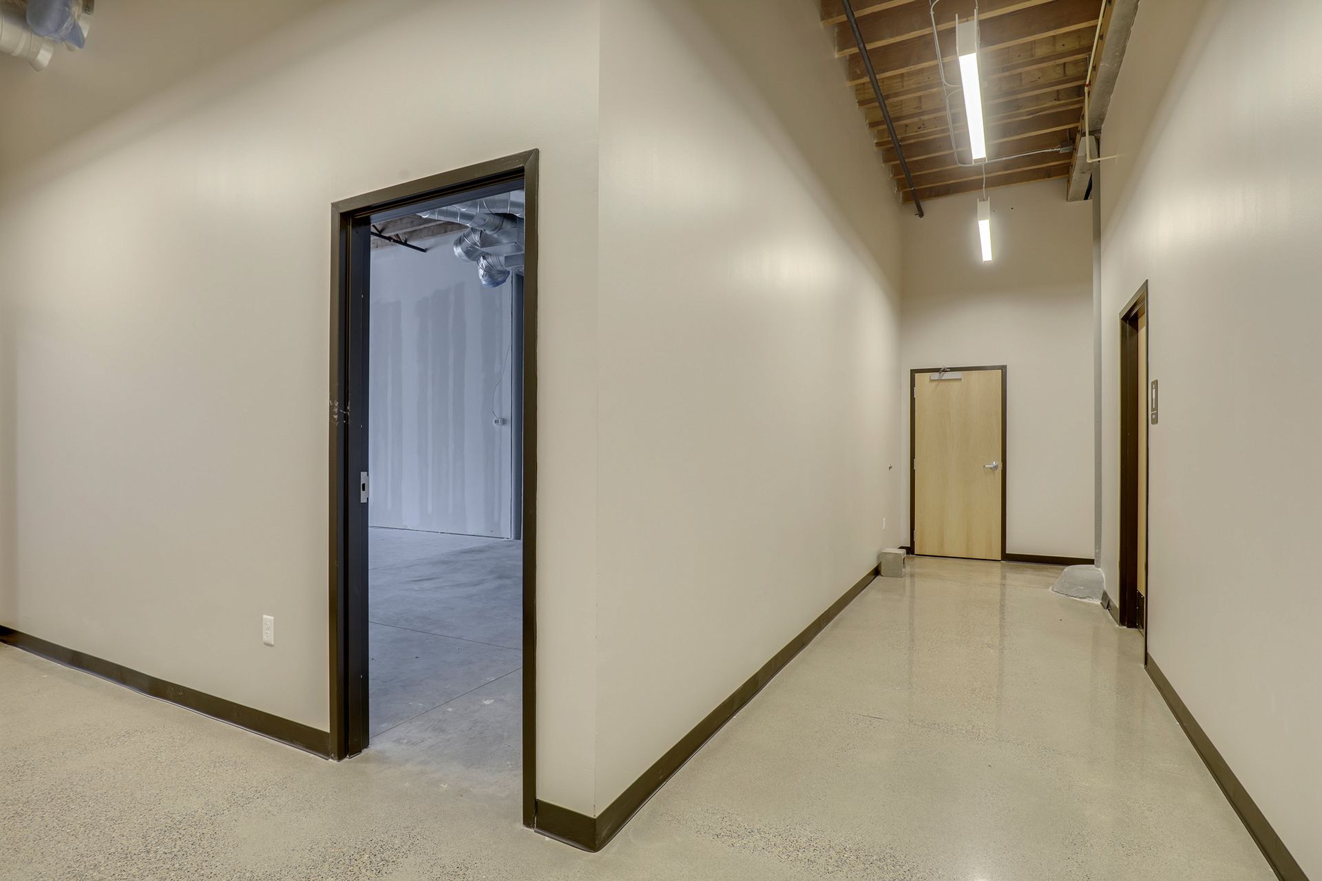 Upper floor corridor with a wood boarded ceiling, terrazzo floor and office doors along one side