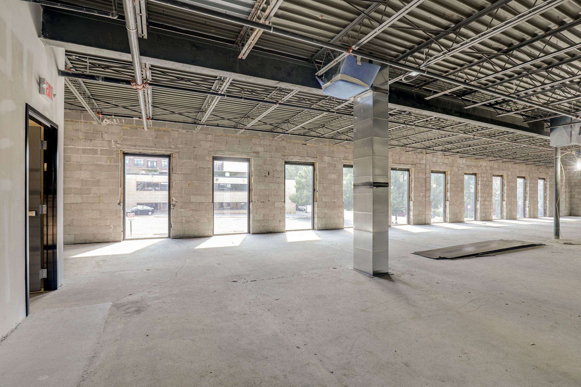 Building shell during construction, with concrete block walls, steel bar joists and storefront openings