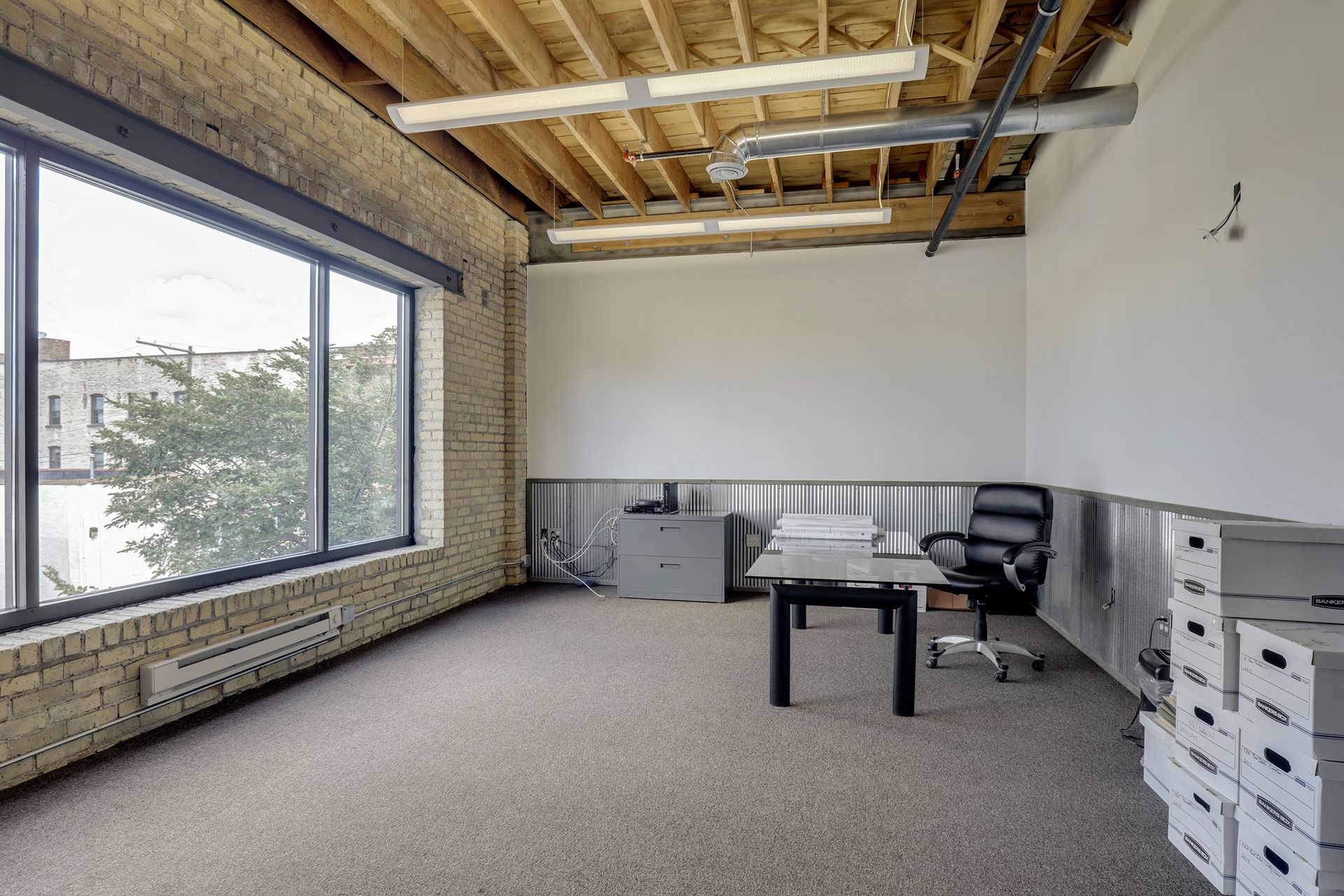 Office with a large window set in a cream brick wall and stacked storage boxes