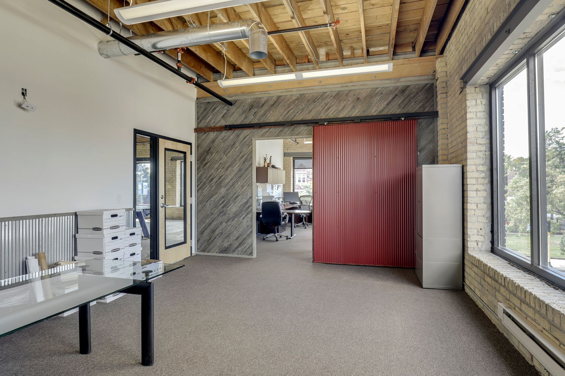 Interior with a red sliding barn door on a black track against a board formed wood accent wall