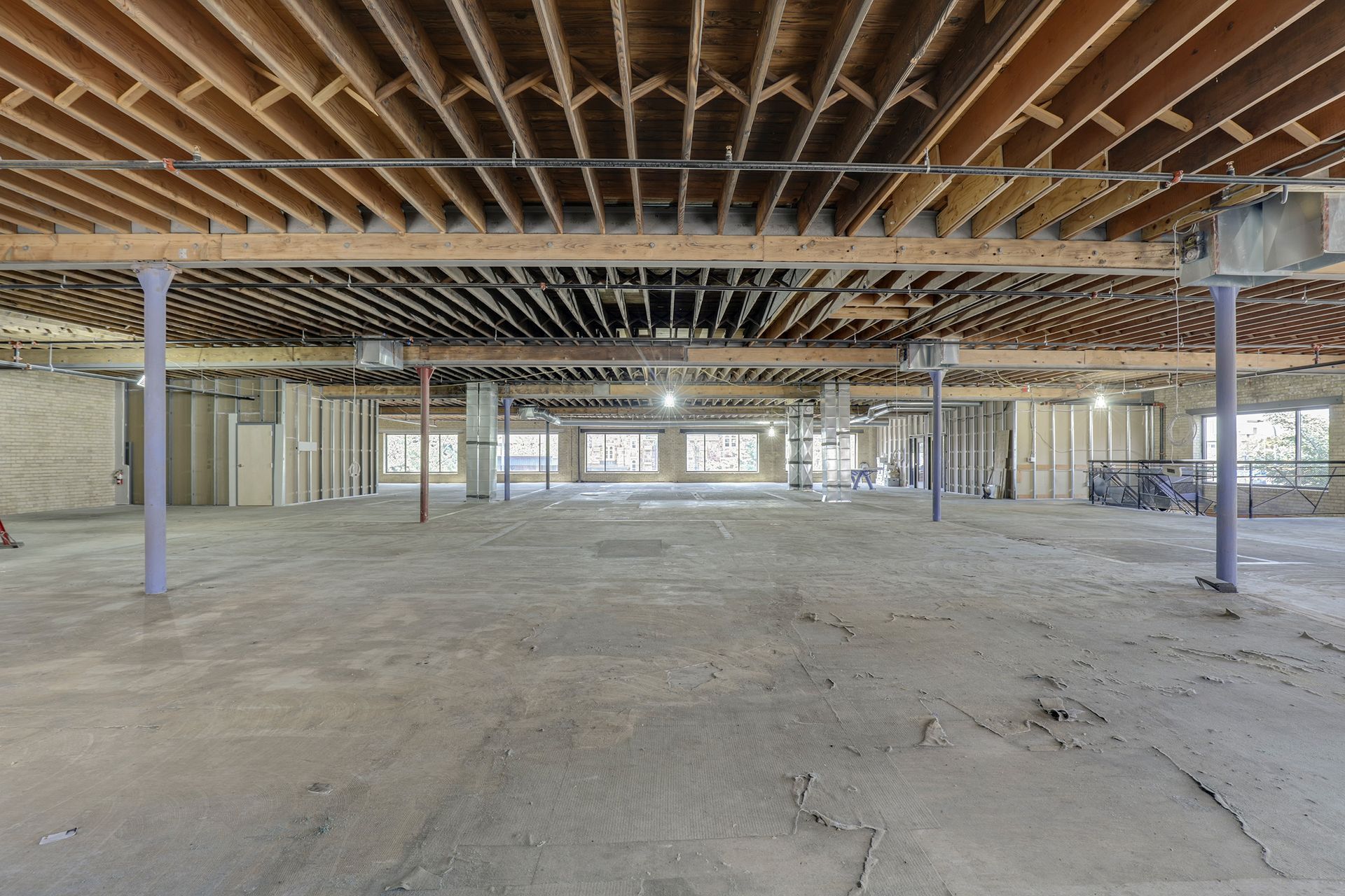 Deep empty floor plate with dense exposed wood joists running overhead
