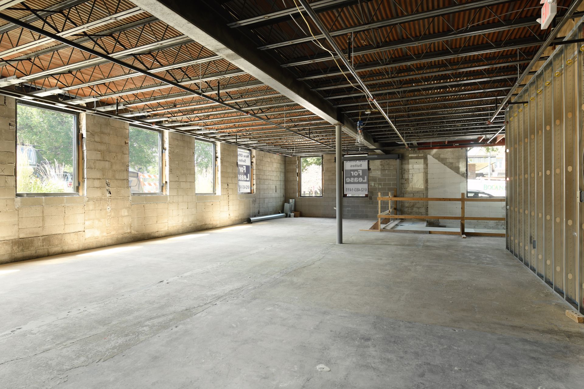 Building shell during construction with concrete block walls, a corrugated deck and timber shelving