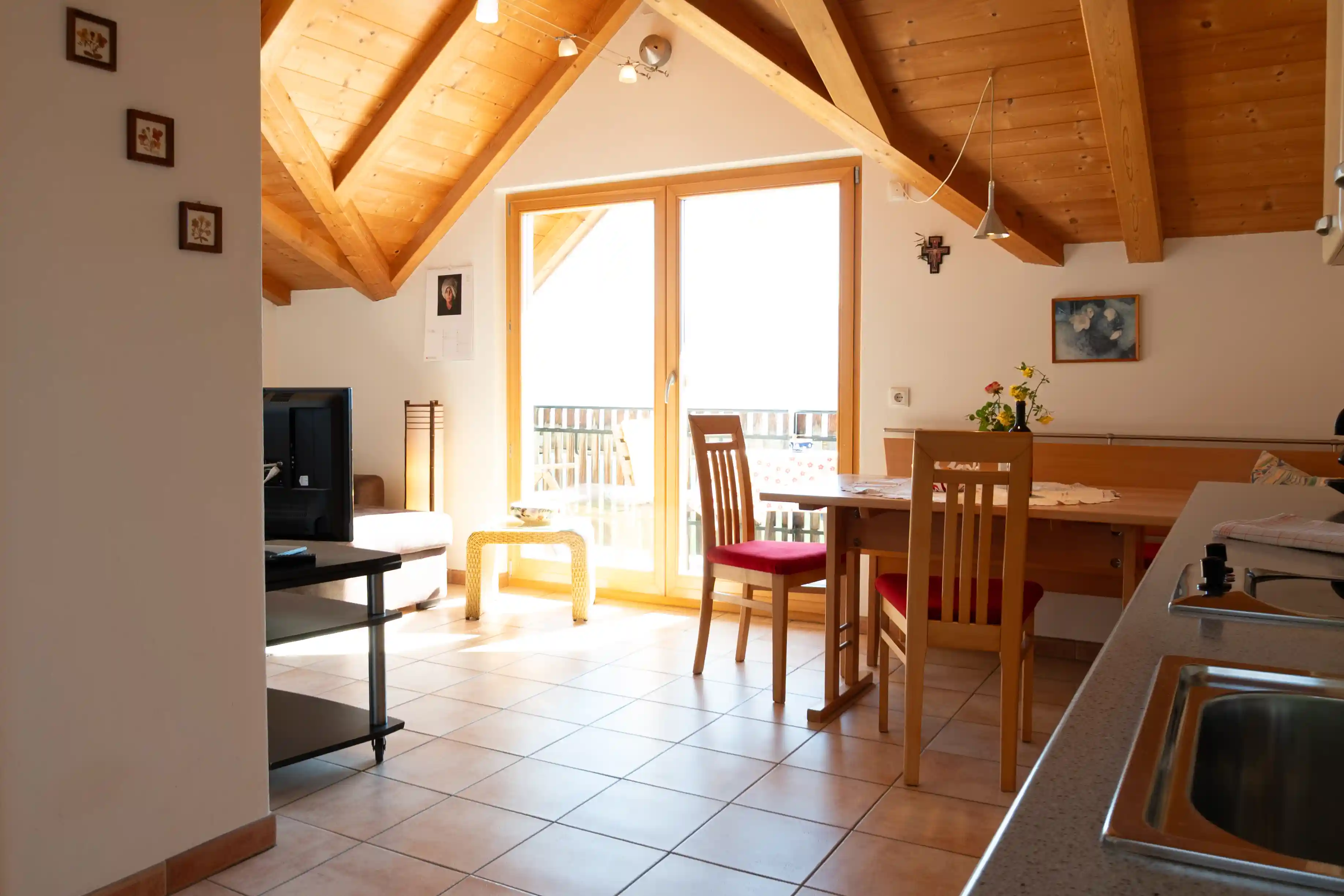 Wohnbereich mit Esstisch und Terrassentür im Appartment Schlern