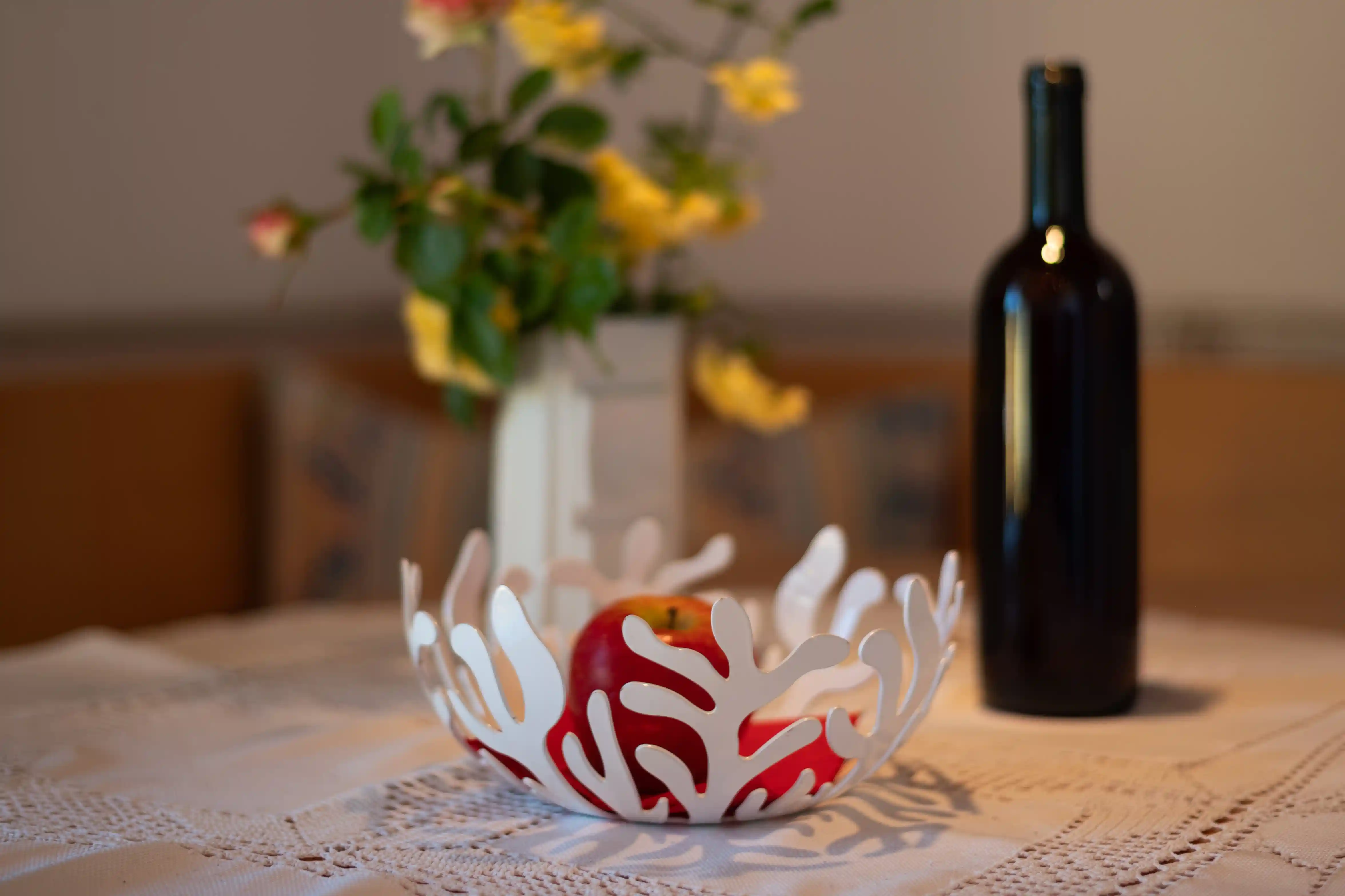 Tisch mit Blumen, Obstschale und Südtiroler Wein im Appartment Schlern