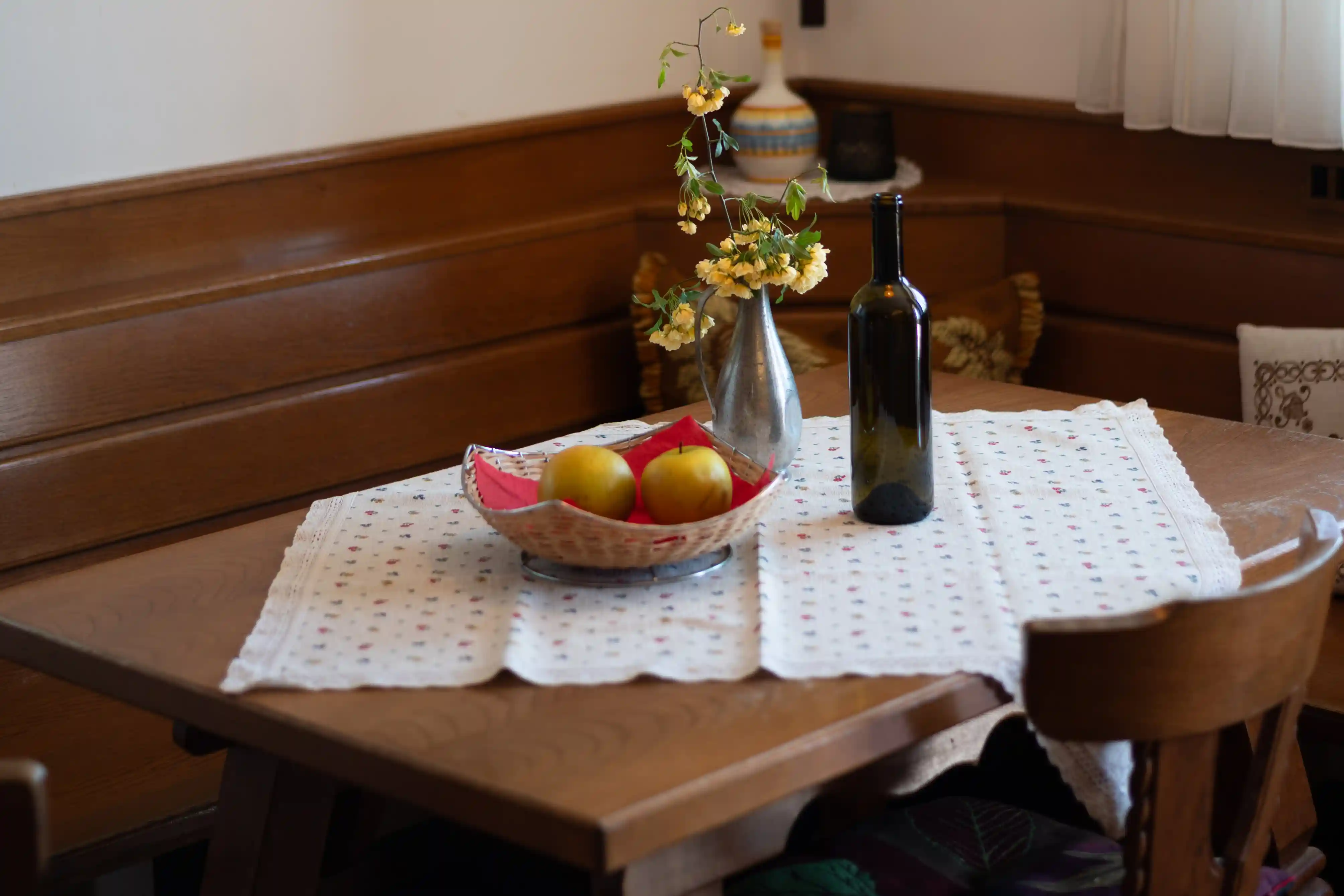 Gedeckter Esstisch mit Obstschale und Wein im Appartment Rosengarten