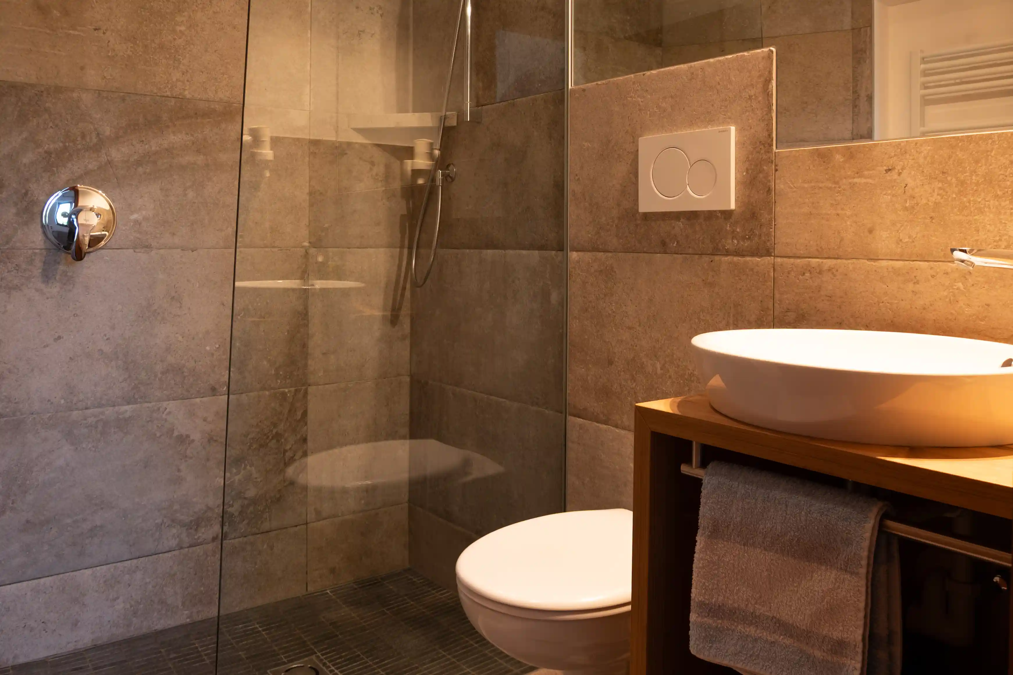 Badezimmer mit Glasdusche und Aufsatzwaschbecken im Appartment Rosengarten