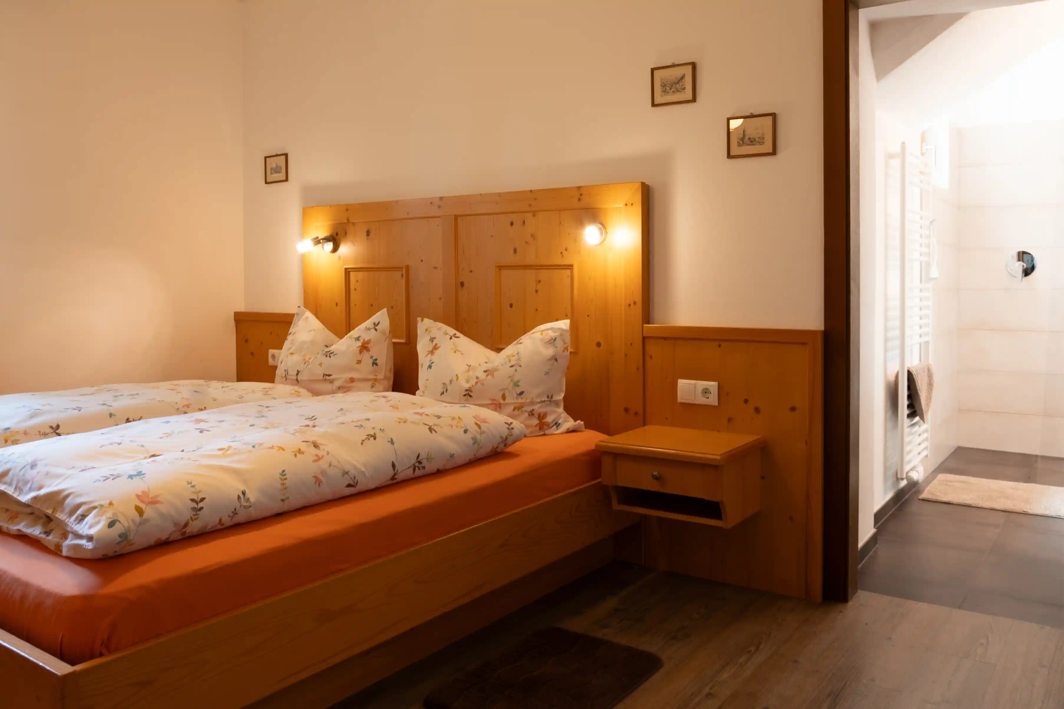 Doppelbett mit Holzkopfteil im Appartment Latemar