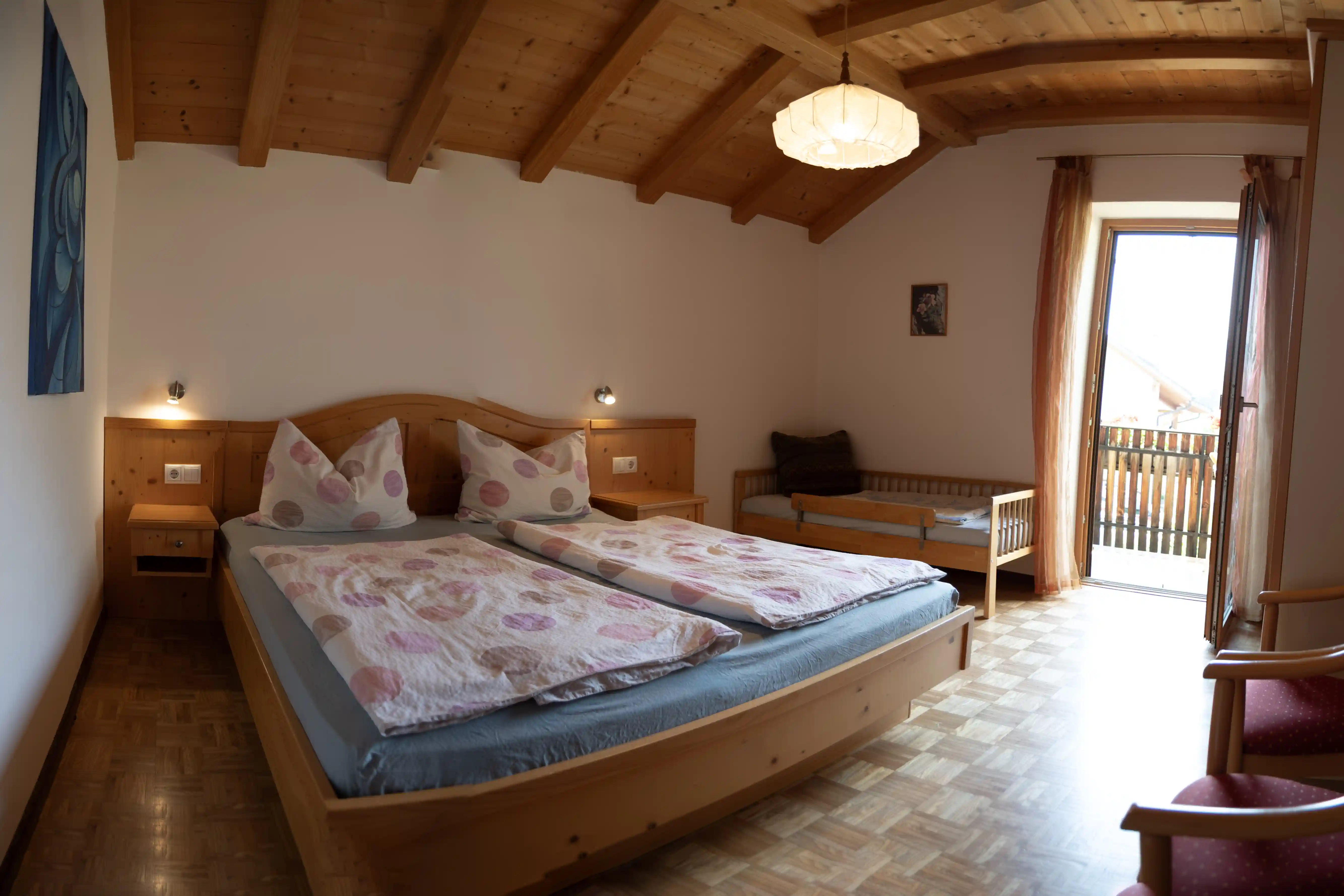 Schlafzimmer mit Doppelbett und Holzdecke im Appartment Weisshorn