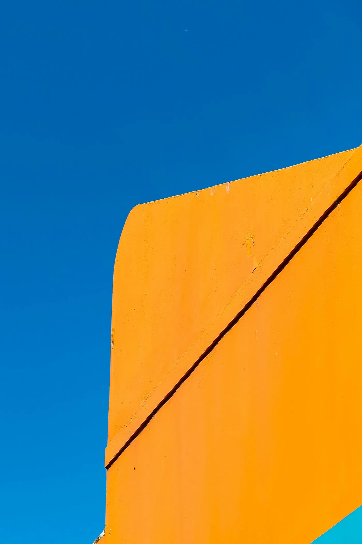 Präzise orange Gebäudekante vor tiefblauem Himmel – Sinnbild für die Umsetzung bei Kaspiya Studio