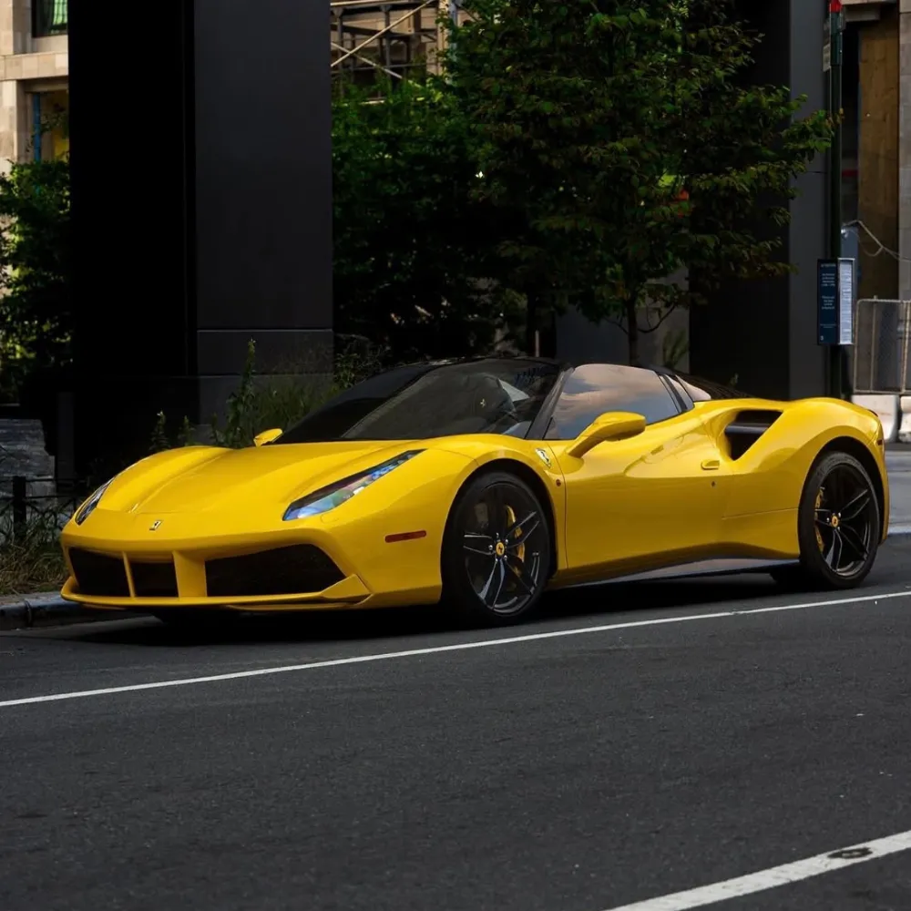 Yellow Ferrari 488 Spyder convertible parked on a city street