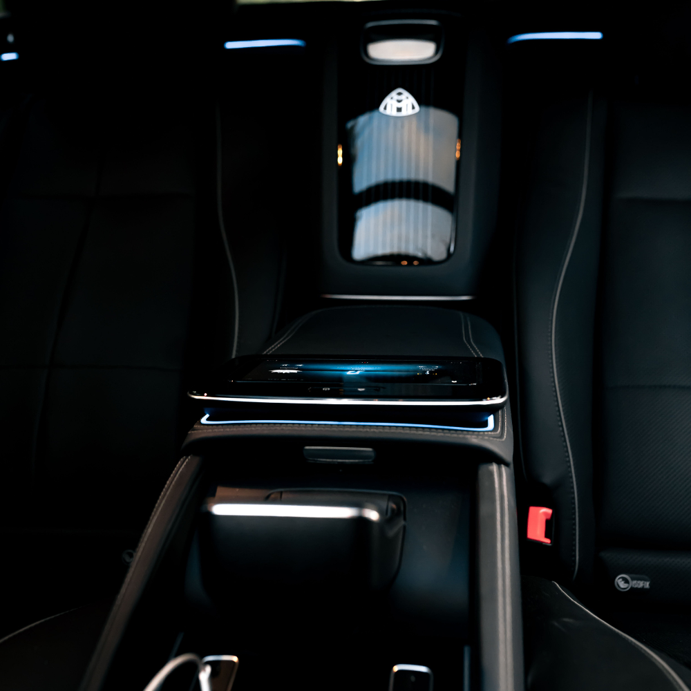 Interior view of a luxury car's center console with a Maybach emblem and leather seats.