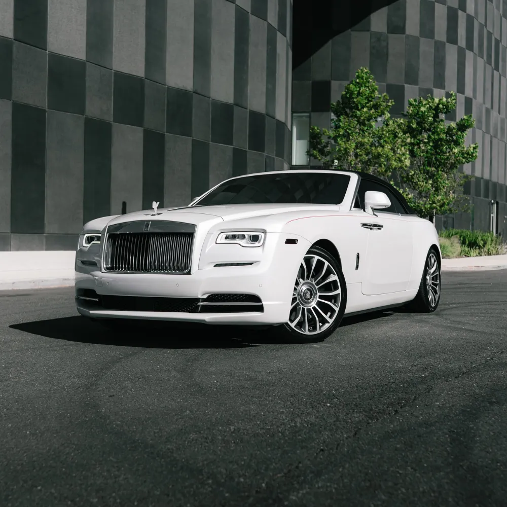 White Rolls-Royce Dawn parked in front of a gray checkered building