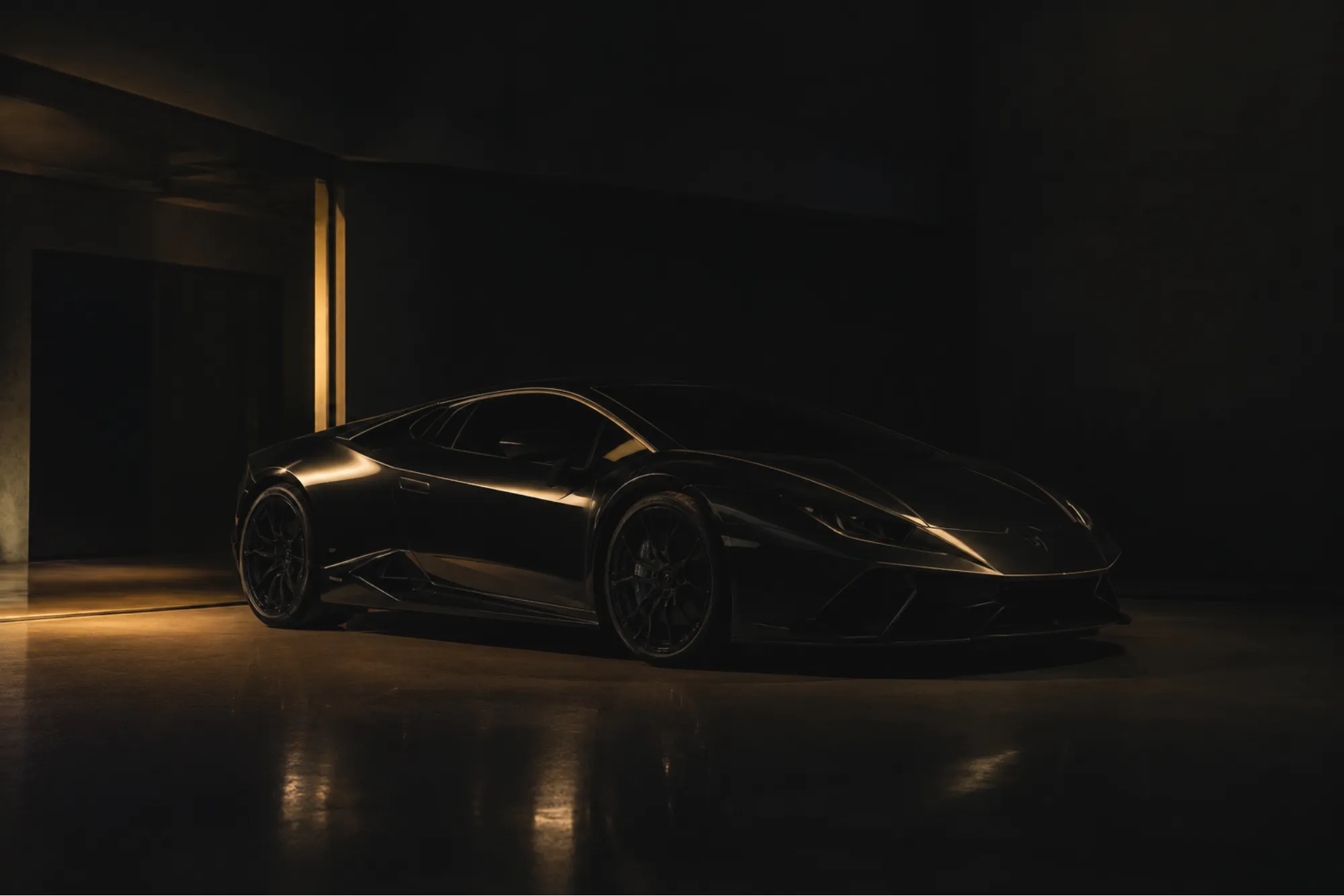 Black sports car in a dark room with warm light on its bodywork
