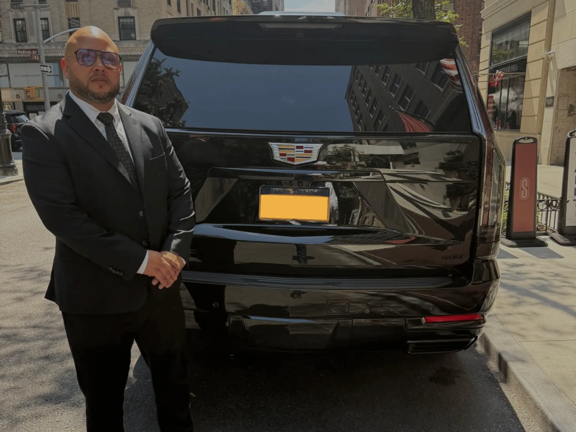 Jorge Molina of Stealth Protection standing at the rear of a black Cadillac SUV