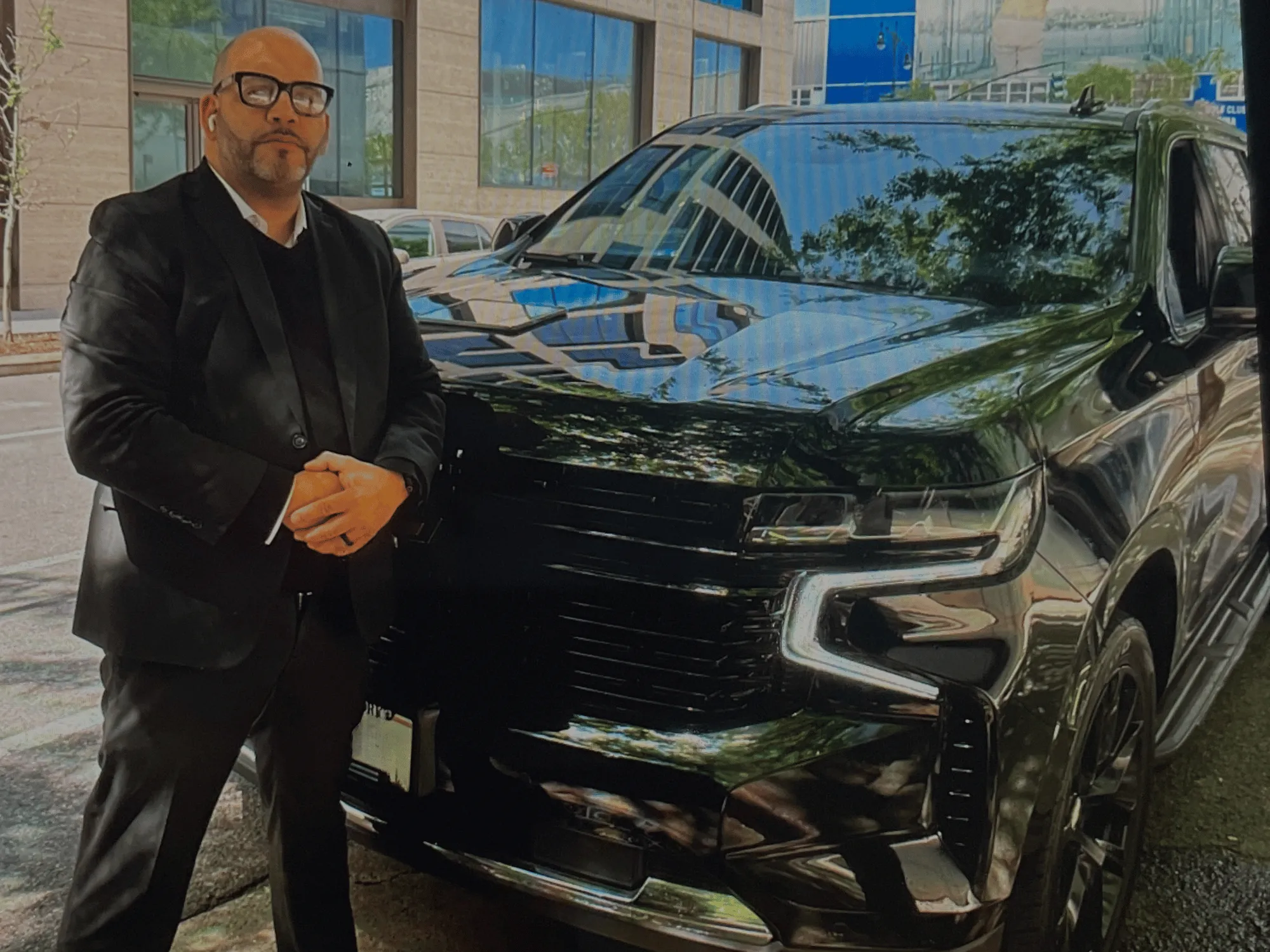 Juan Garcia of Stealth Protection standing beside a black SUV