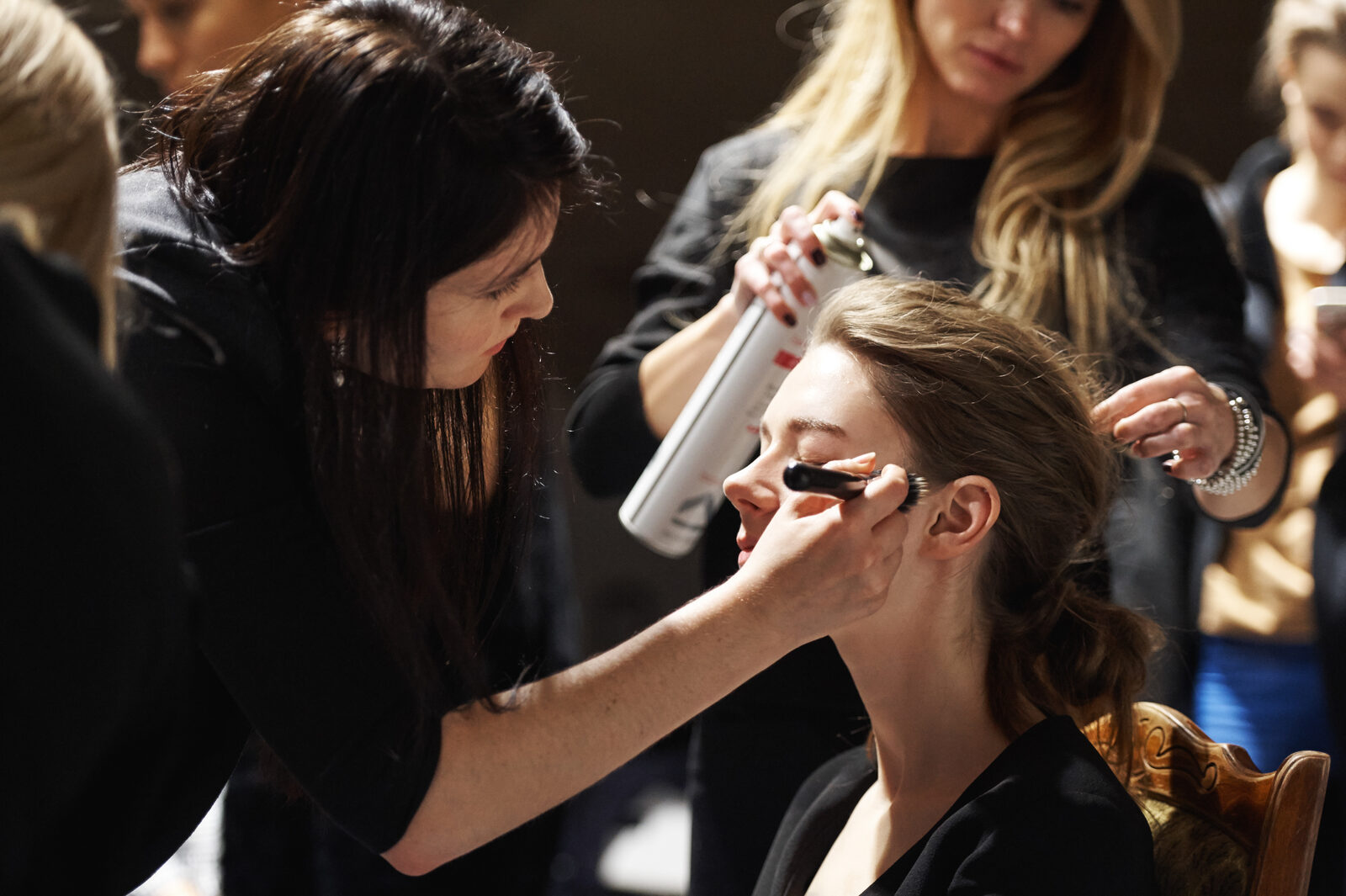 Makeup artist teaching a student on set